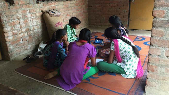 A group of children watch English videos on a tablet in a village. | Representational Image | Commons