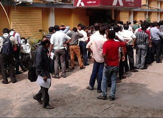 Bhutan - People standing in queue outside ATM