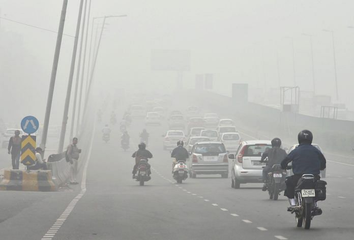 People driving through smog on Delhi roads