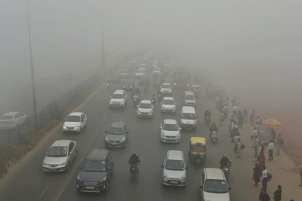 Cars plying through smog in Delhi