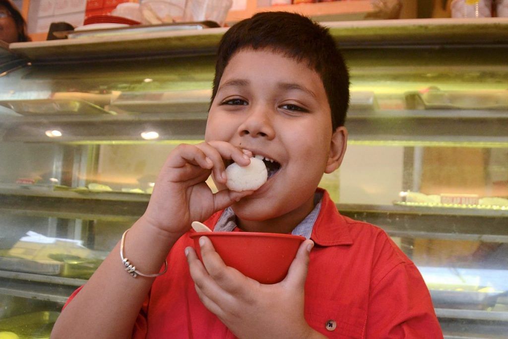 A boy eating rasogolla at a sweets shop in Kolkata on Tuesday