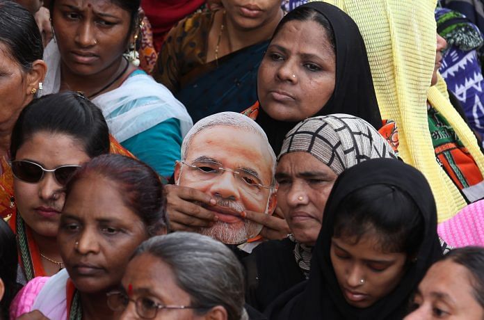 Women holding Modi masks