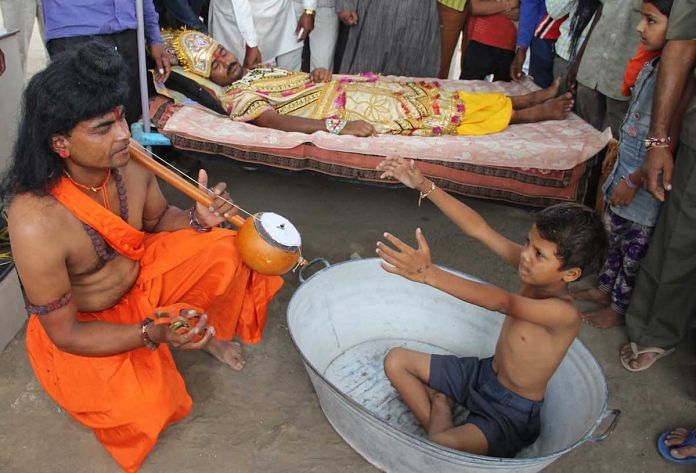 A boy prays to a man dressed as Narada to invoke rains.