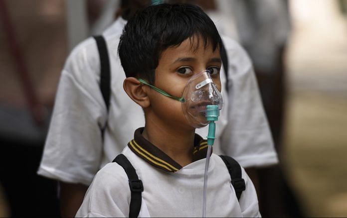 School children wear oxygen masks to protect themselves from air pollution in Delhi