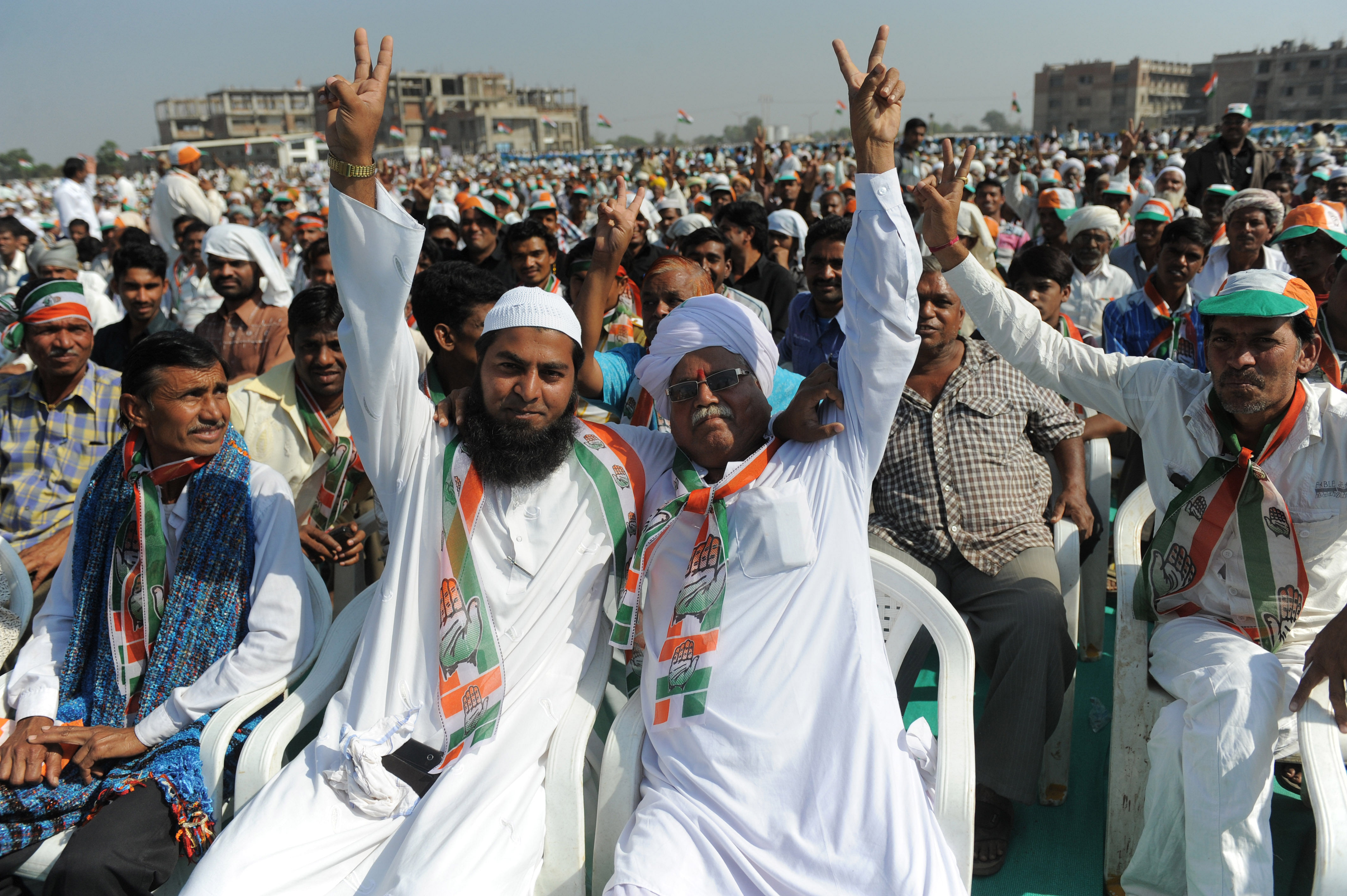 A hindu and a muslim making a victory sign in a political rally in Gujarat