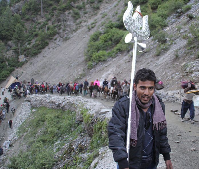 A man leading pilgrims to the Amarnath caves, holding a Trishul