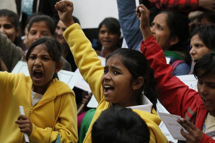 a young girl participating in a protest against sexual abuse against women
