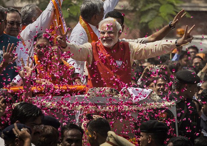 Supporters throw flower petals at BJP leader Narendra Modi