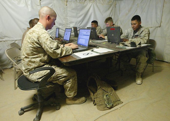 U.S. marines using computers in a tent