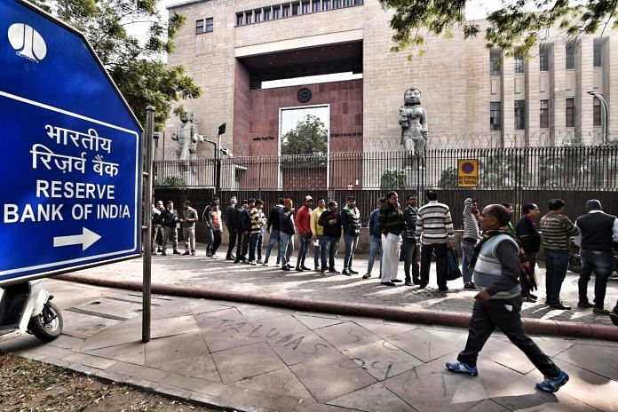 People stand in queue in front of RBI