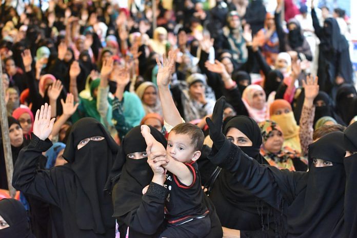 muslim women holding a babt, celebrating the triple talaq bill