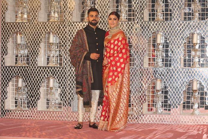 Anushka Sharma and Indian Cricket captain Virat Kohli pose for photographers during their reception