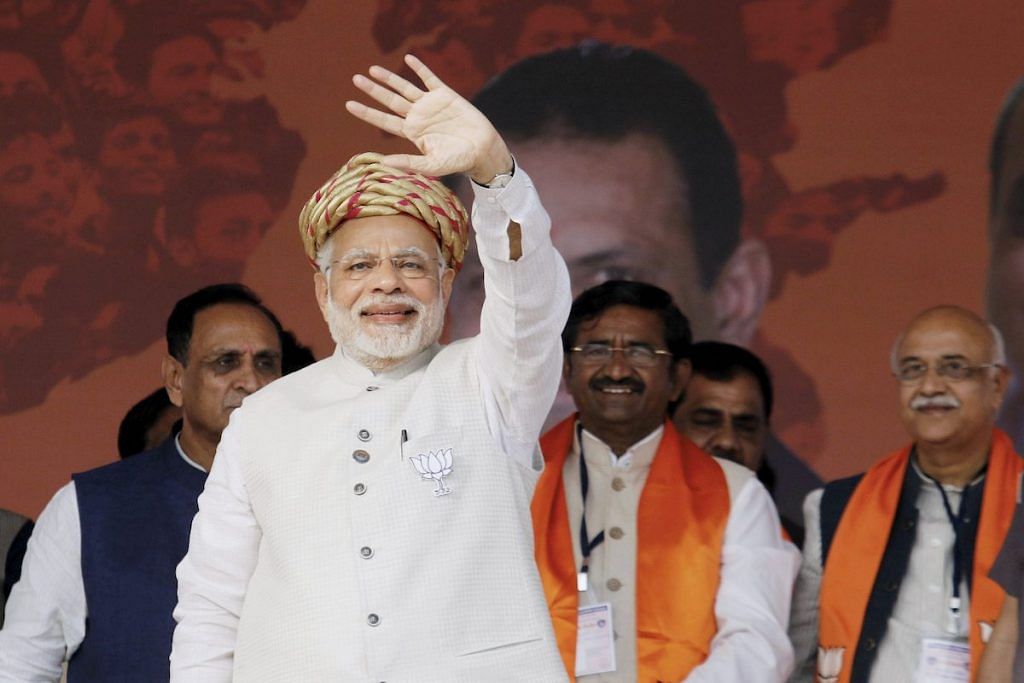 Prime Minister Narendra Modi waves to the crowd during an election campaign rally
