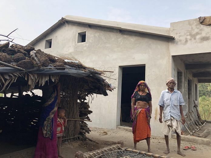 Tribal Family in front of under construction house allotted in Gujarat