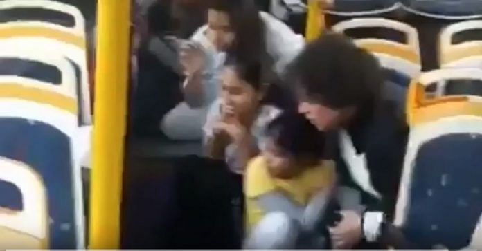 A woman and children crouched on the floor of the GD Goenka World School bus
