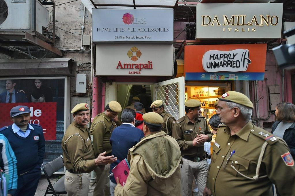 Police personnel outside shops in the Khan Market, in New Delhi on Monday.