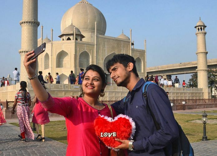 A young couple takes a selfie in front of the Taj Mahal replica