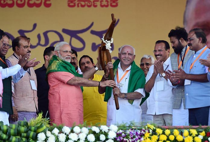 Prime Minister Narendra Modi hands over a model of polugh to Karnataka BJP President and chief ministerial candidate B S Yeddyurappa during the party's 'Farmers Convention' at Davanagere