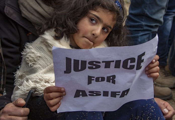 A child holds a placard as she takes part in a protest demanding the death penalty for the suspects in the rape and murder of an eight-year-old girl | Yawar Nazir/Getty Images