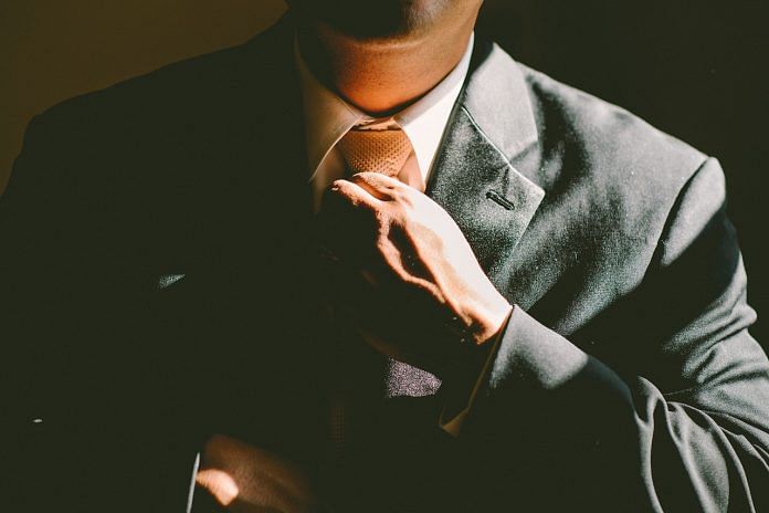 Image of a man adjusting his tie