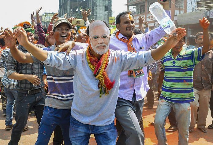Agartala: A BJP supporters wear a mask of Prime Minister Narendra Modi to celebrate party's victory in Tripura Assembly elections in Agartala on Saturday