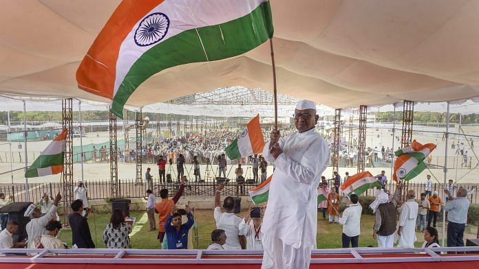 Social activist Anna Hazare waves a tri-colour during his indefinite hunger strike in New Delhi | PTI