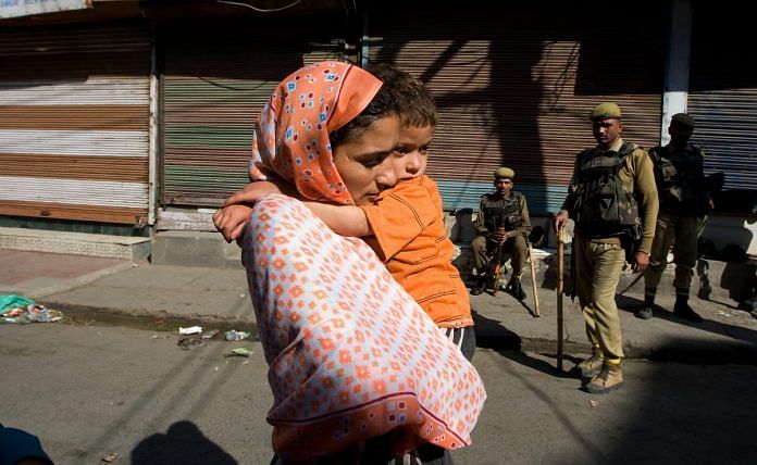 A mother carries her child to a doctor during a curfew in Kashmir| Paula Bronstein/Getty Images