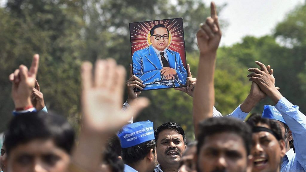Members of Dalit community display a portrait of Bhim Rao Ambedkar during 'Bharat Bandh' in New Delhi | PTI