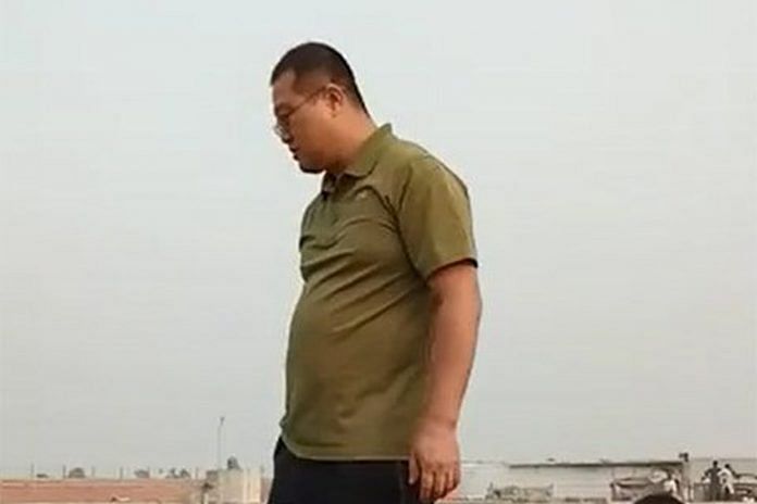 A Chinese worker standing on top of Pakistani police vehicle