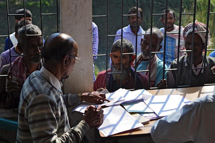 People wait to check their names on the first draft of the National Register of Citizens (NRC) in Assam