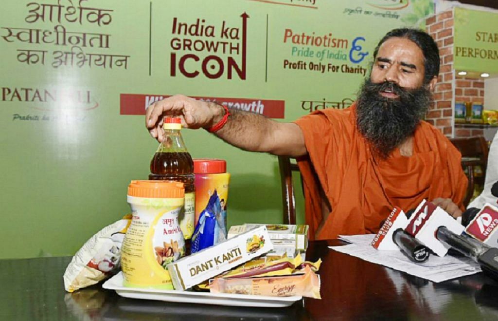 Baba Ramdev shows Patanjali's products during a press conference in Delhi