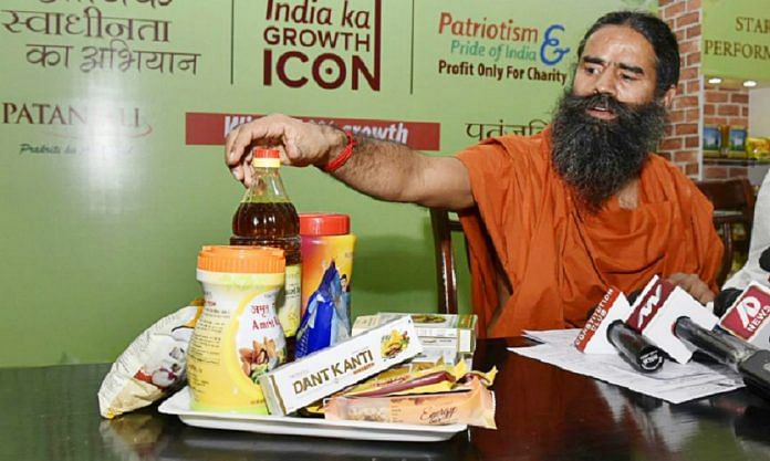 Baba Ramdev shows Patanjali's products during a press conference in Delhi