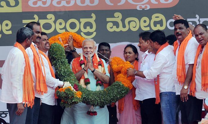 PM Narendra Modi being garlanded by BJP workers at an election campaign rally | PTI