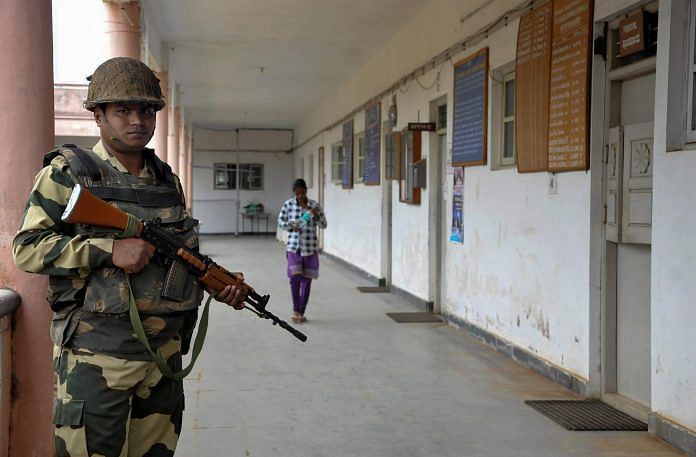 A security personnel stands guard outside a room where Electronic Voting Machines (EVM's) are kept after the voting, at Chikmagalur in Karnataka on Monday