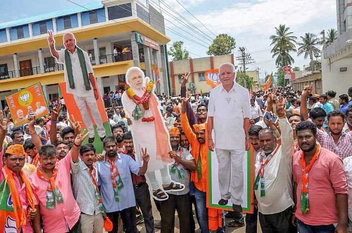 BJP workers hold the cut-outs of Modi and B S Yeddyurappa as they celebrate the Karnataka Assembly elections 2018 results | PTI