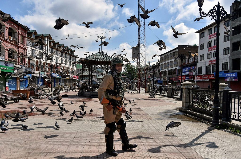 A security person stands guard during at Srinagar's Lal Chowk during a strike