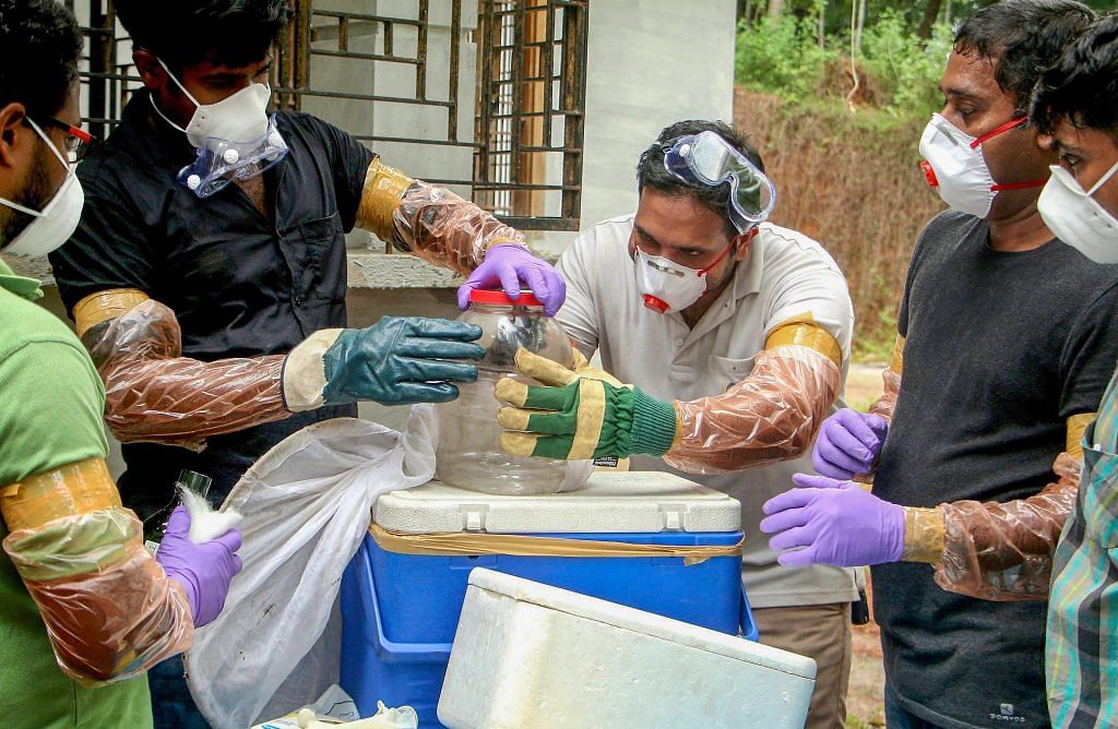 Animal Husbandry department and forest officials collect bats from a well of a house after the outbreak of 'Nipah' virus