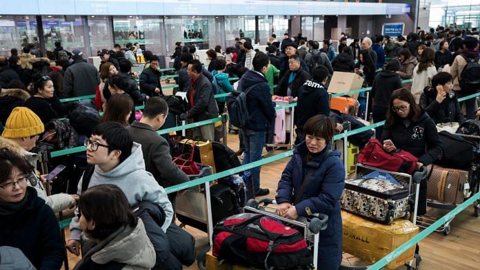 Travelers wait in line to check-in at Incheon International Airport in Incheon, South Korea