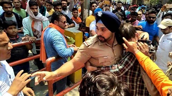 Sub-inpector Gagandeep Singh protects the boy from the mob in Ramnagar | @DrKiran Randhawa | Facebook