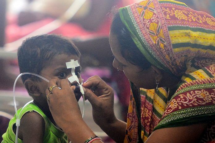 A woman looks after her child at the encephalitis ward of the the Baba Raghav Das Hospital, Gorakhpur