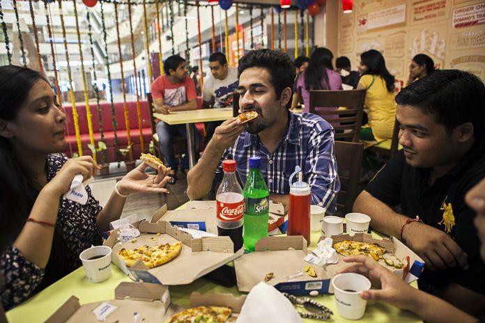 Customers eat at a Domino's Pizza outlet, operated by Jubilant Foodworks Ltd.
