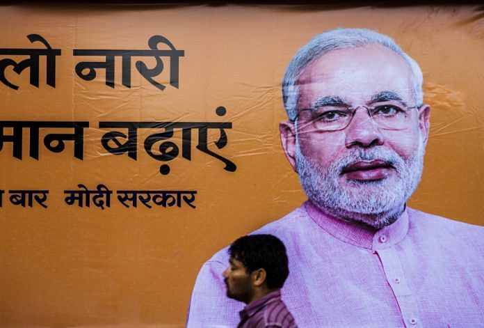 A pedestrian walks past a billboard for the Bharatiya Janta Party (BJP)