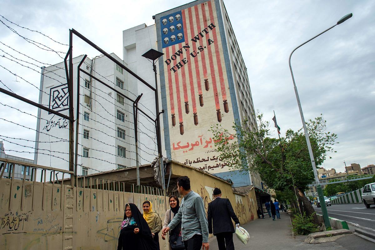 Pedestrians pass a giant wall mural proclaiming 'Down With The USA' on a street in Tehran, Iran | Ali Mohammadi/Bloomberg