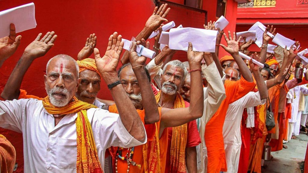 Sadhus wait in a queue to get themselves registered for Amarnath Yatra, at a base camp in Jammu | PTI