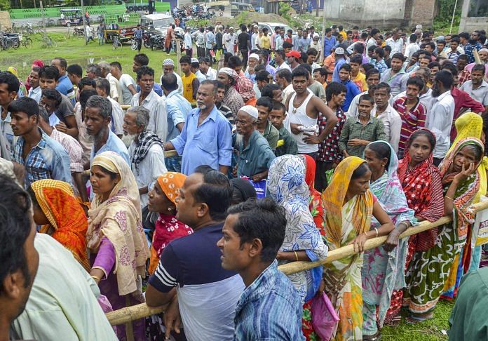 People wait to check their names on the final draft of the state's NRC | PTI