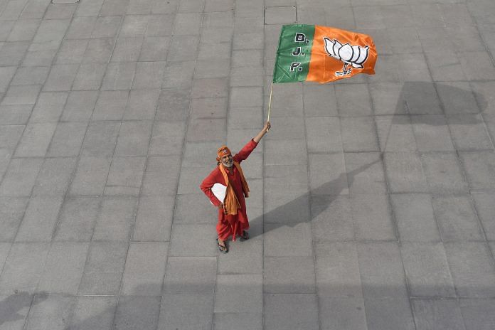 A man holds a flag of Bharatiya Janata Party at the courtyard of the party's headquarters in New Delhi (REPRESENTATIONAL IMAGE) | Anindito Mukherjee/Bloomberg