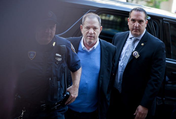 Harvey Weinstein, former co-chairman of the Weinstein Co., center, is escorted in handcuffs to Manhattan Criminal Court in New York, U.S. $~ Michael Nagle/Bloomberg