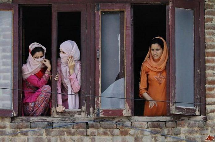 Kashmiri women watch a rally from a window in Srinagar ~ Commons