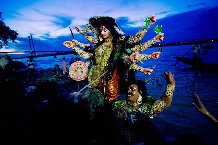 Devotees carry an idol of goddess Durga to immerse it in the Ganga in Kolkata | Daniel Berehulak/Getty Images