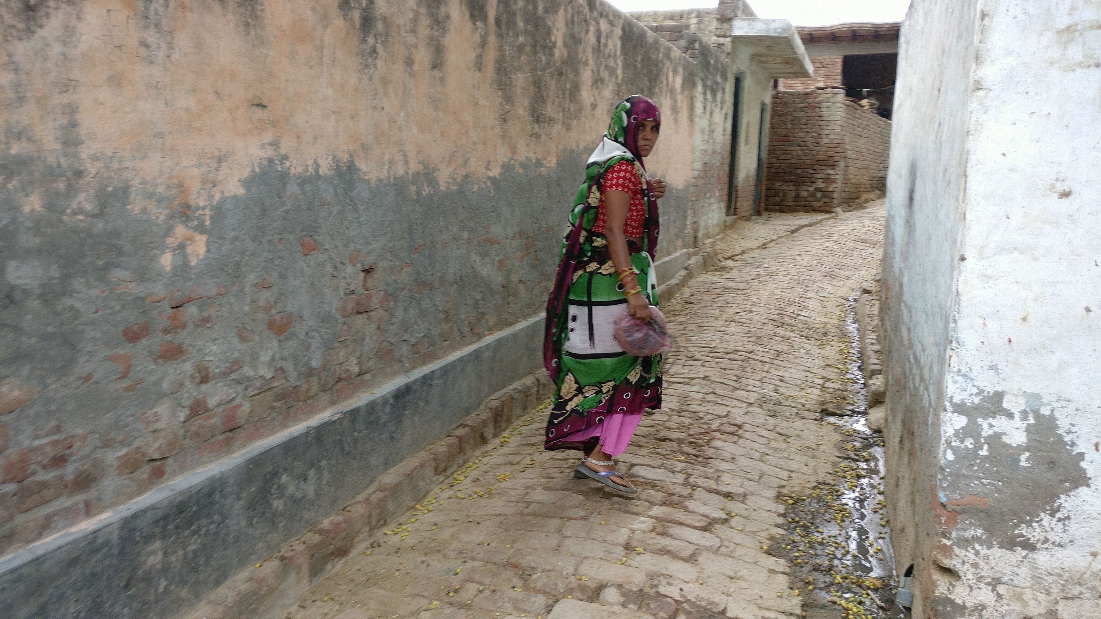 Shivkumar's mother, Rajkumari, walking towards her house in Sonda village | ThePrint.in